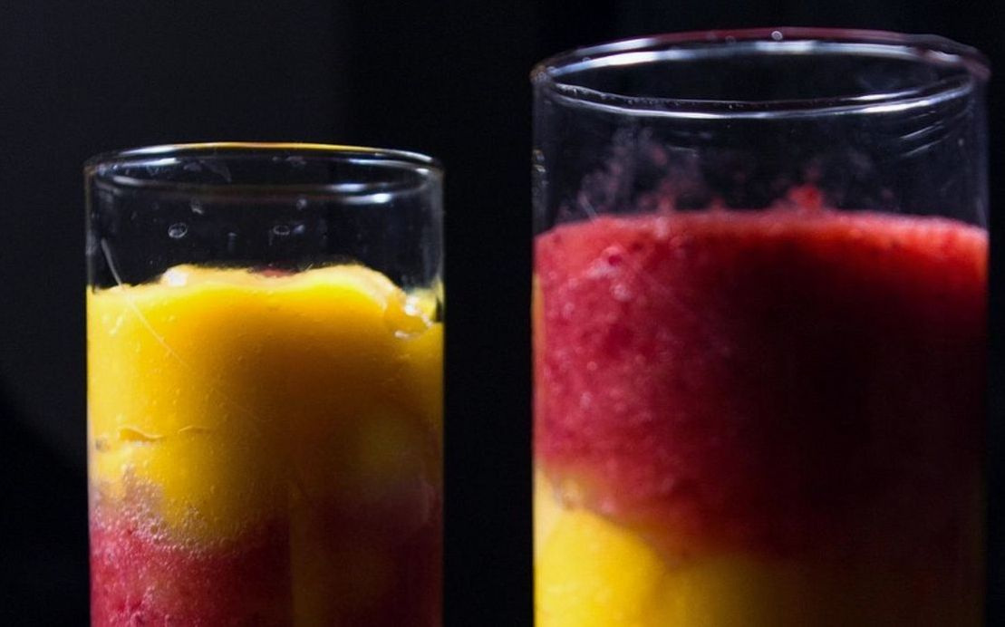 Una manzana recién cortada junto a un jugo fresco de naranja
