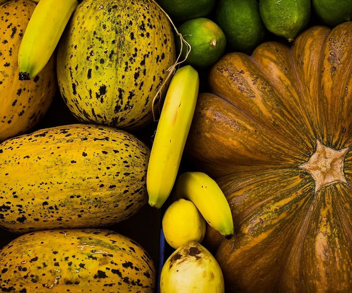 Mostrador lleno de frutas frescas y licuadoras en funcionamiento